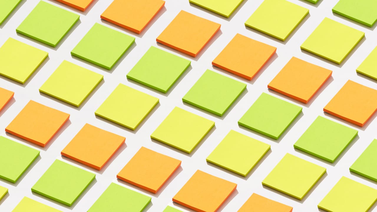 Sticky notes in orange and green arranged on a white background.