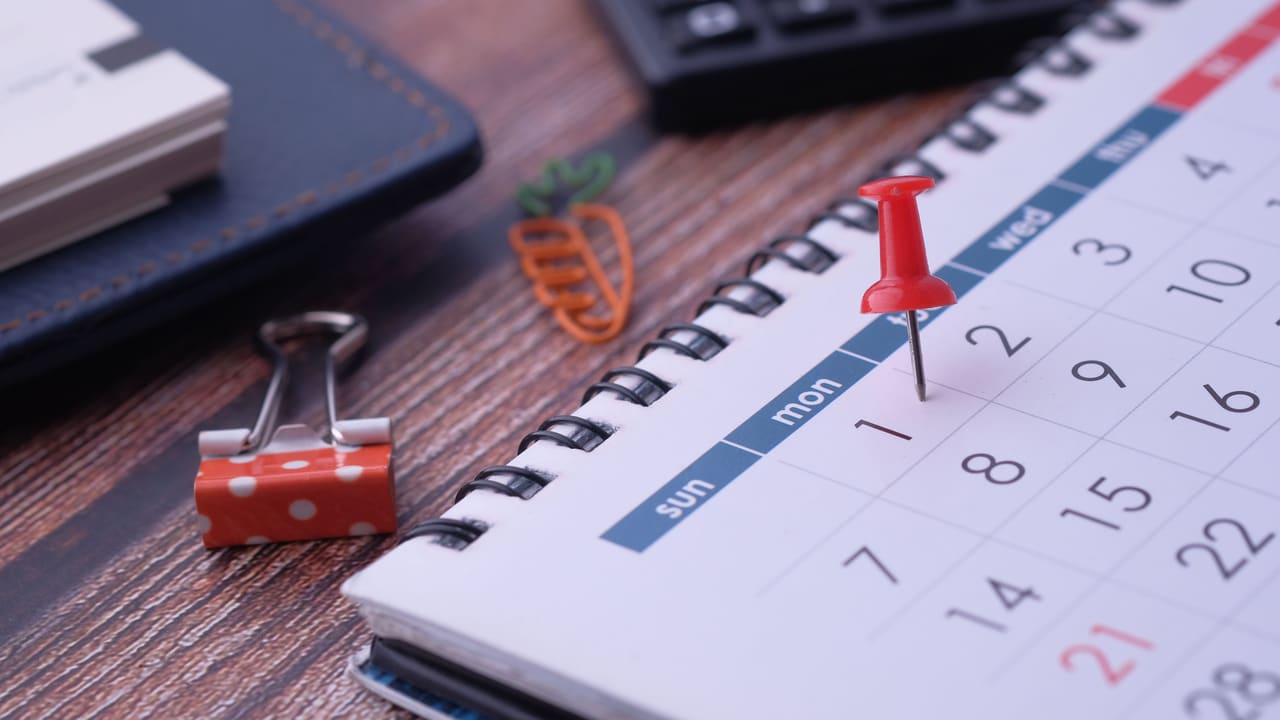 A desk calendar and pins laid out for planning.