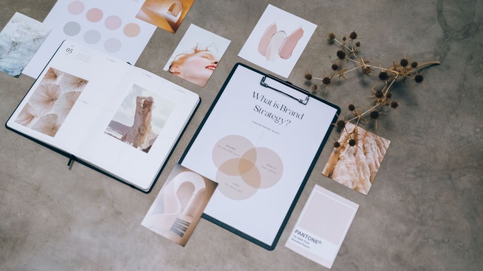 Flat lay of branding strategy materials with moodboard and color palette for creative design.