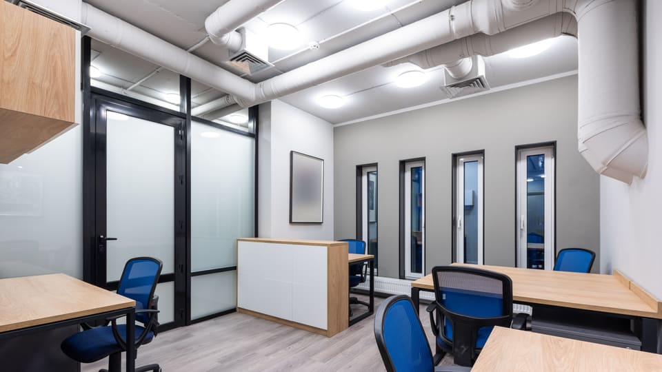 Interior of new contemporary spacious workplace with wooden desks and blue office chairs