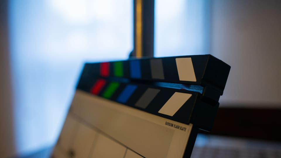 Detailed view of a film clapperboard indoors, highlighting film industry tools.