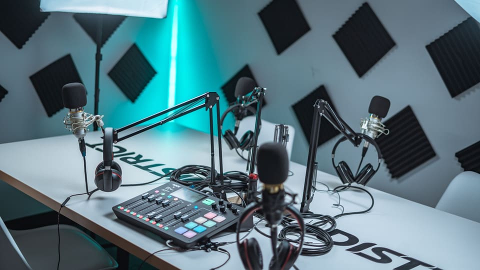 Sleek podcast studio setup featuring microphones, audio mixer, and acoustic panels.